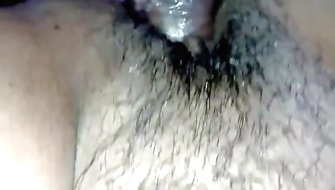 A brunette girl is wearing a black dress and a black sweater